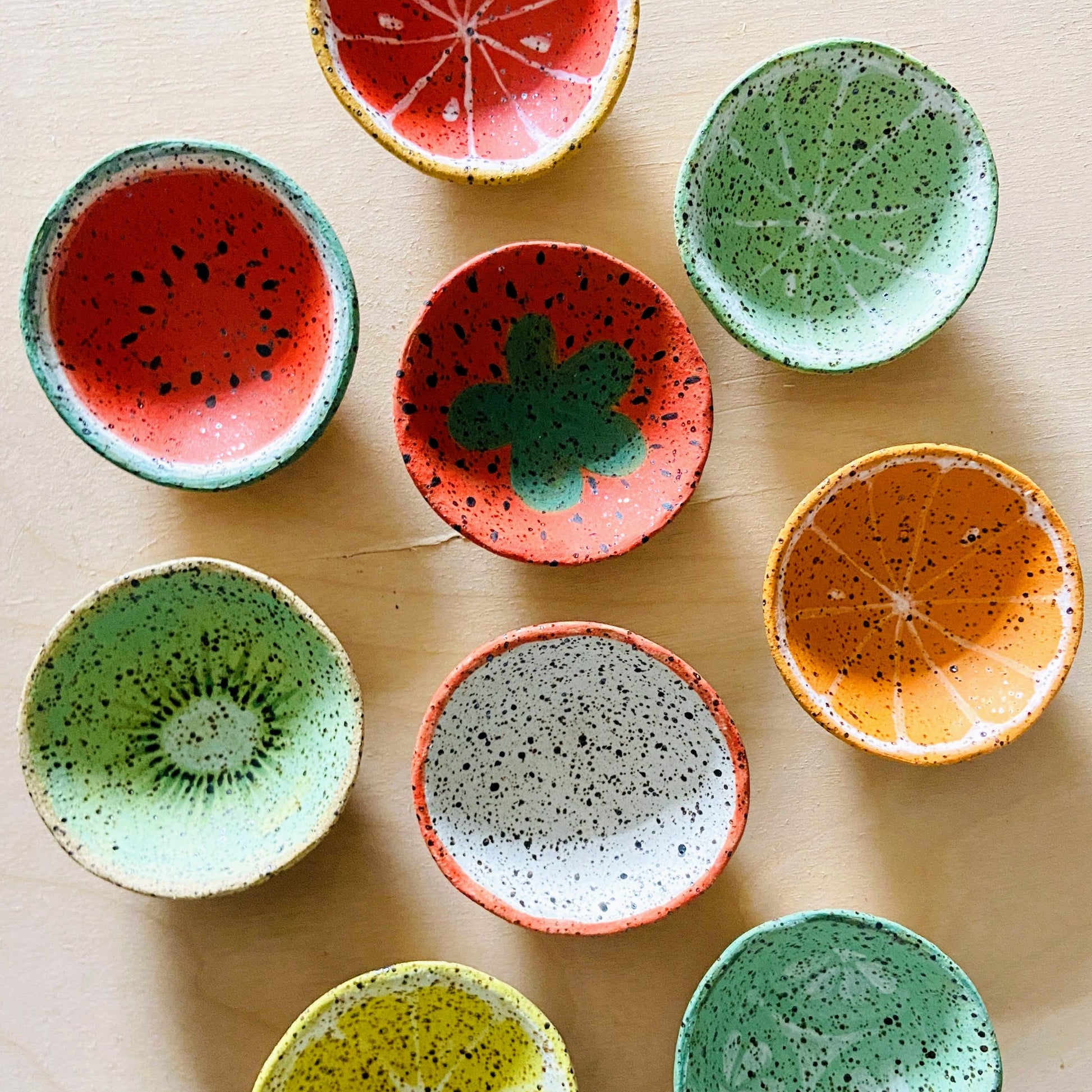 Colorful ceramic bowls shaped like watermelon slices on a light background